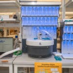 A laptop running PeptiVerse, at left, next to machines used to synthesize peptides, center and at right. Researchers can use PeptiVerse to predict the properties of peptides before incurring the time and expense required to synthesize them. Credit: Sylvia Zhang, Penn Engineering