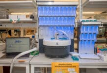 Open-Source AI Predicts Peptide Properties A laptop running PeptiVerse, at left, next to machines used to synthesize peptides, center and at right. Researchers can use PeptiVerse to predict the properties of peptides before incurring the time and expense required to synthesize them. Credit: Sylvia Zhang, Penn Engineering