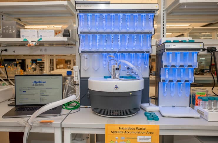 A laptop running PeptiVerse, at left, next to machines used to synthesize peptides, center and at right. Researchers can use PeptiVerse to predict the properties of peptides before incurring the time and expense required to synthesize them. Credit: Sylvia Zhang, Penn Engineering