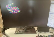 Basys3 FPGA board rendering a colorful low-poly 3D rabbit model on a Dell monitor, running the TinyGPU graphics pipeline