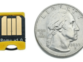 The Bitmerse Romu next to a coin, highlighting its ultra-compact $15.5 \times 12\text{ mm}$ form factor designed to fit entirely inside a USB-A port