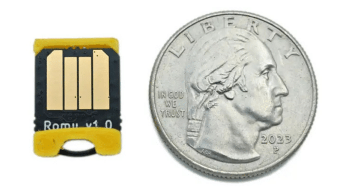 The Bitmerse Romu next to a coin, highlighting its ultra-compact $15.5 \times 12\text{ mm}$ form factor designed to fit entirely inside a USB-A port