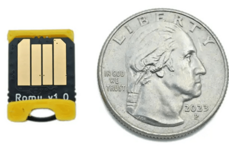 The Bitmerse Romu next to a coin, highlighting its ultra-compact $15.5 \times 12\text{ mm}$ form factor designed to fit entirely inside a USB-A port